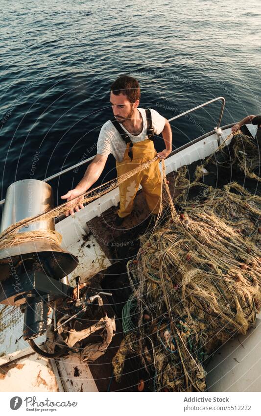 Fischer, der vom Segelboot aus im offenen Meer fischt Boot MEER Fischen Netz Schoner Arbeit Uniform Fokus männlich Soller Balearen Mallorca Wadenfisch jagen