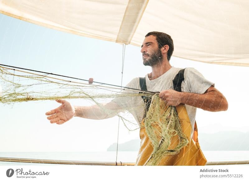 Fischer, der vom Segelboot aus im offenen Meer fischt Boot MEER Fischen Netz Schoner Arbeit Uniform männlich Soller Balearen Mallorca Wadenfisch Fokus jagen