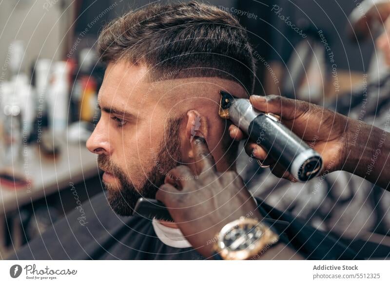 Friseur, der das Haar eines männlichen Kunden trimmt Männer Klient Haarschnitt entgittern Behaarung Trimmer Barbershop Genauigkeit Schönheit jung