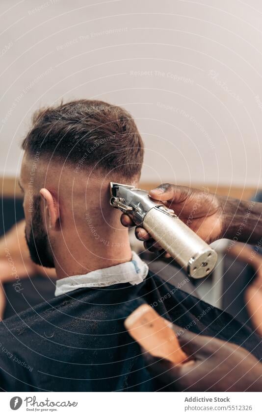 Friseur, der das Haar eines männlichen Kunden trimmt Männer Klient Haarschnitt entgittern Behaarung Trimmer Barbershop Genauigkeit Schönheit jung