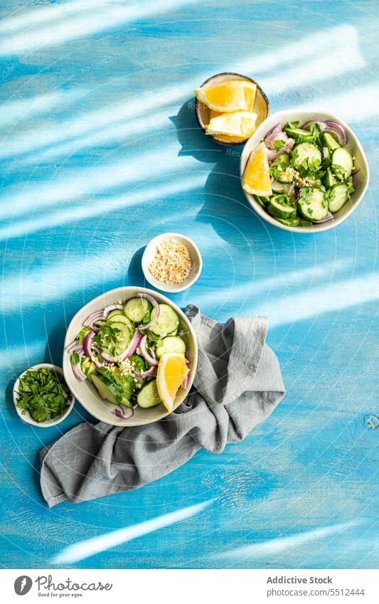 Ansicht von oben auf gesunde Gemüsesalate Salatbeilage organisch Gewürz Salatgurke Vegetarier Schalen & Schüsseln Zwiebel Kraut Paprika Zitrone Murmel mischen