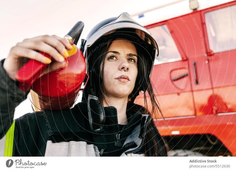 Tapfere Feuerwehrfrau mit Feuerlöscher Frau Feuerwehrmann Feuerwehrauto Lastwagen Rettungsdienst Mut Hilfsbereitschaft Held ernst jung Schwarzes Haar Notfall