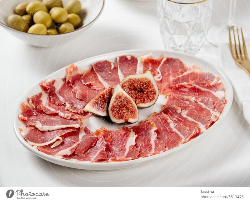 Jamon auf einem Teller mit Feigen Jamón Schinken Amuse-Gueule Lebensmittel Restaurant lecker Fleisch Schweinefleisch Feinschmecker Snack geheilt Feinkostladen