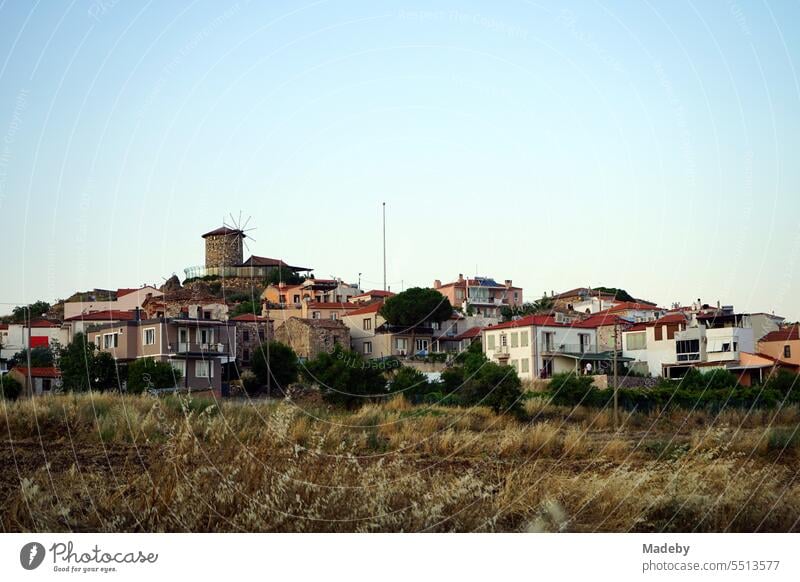 Alte türkische Windmühle im Licht der Abendsonne auf einem Hügel mit Altstadt der Halbinsel in Cunda bei Ayvalik am Ägäischen Meer in der Provinz Balikesir in der Türkei