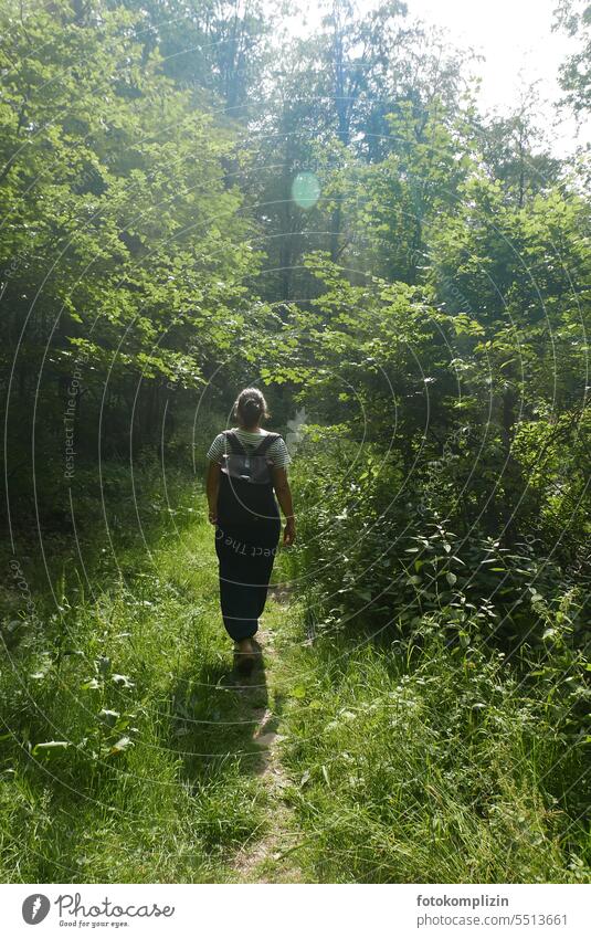 Frau läuft im Grünen einen Pfad entlang Weg Natur Wald wandern spazieren Spaziergang Bäume Waldweg Wege & Pfade Landschaft Baum grün Spazierweg Erholung ruhig