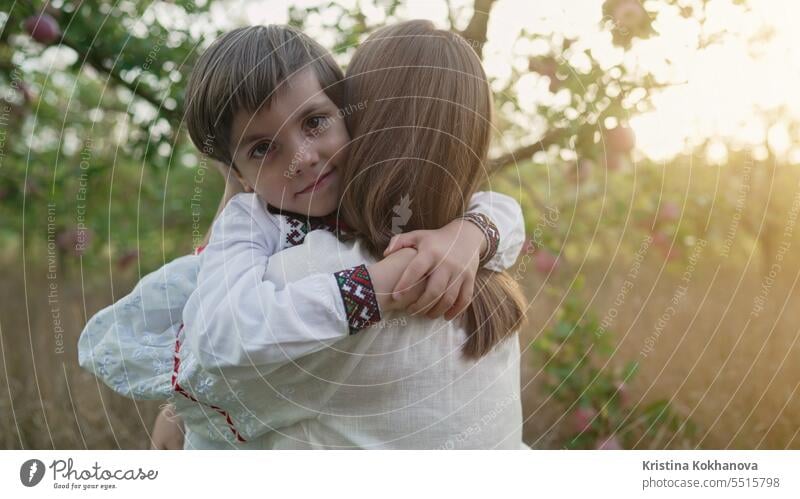 Porträt einer schönen Familie - 4 Jahre alter Junge und Mutter im Apfelgarten. Mama Sohn Glück Umarmung Liebe Eltern Pflege Fröhlichkeit umarmend Mutterschaft