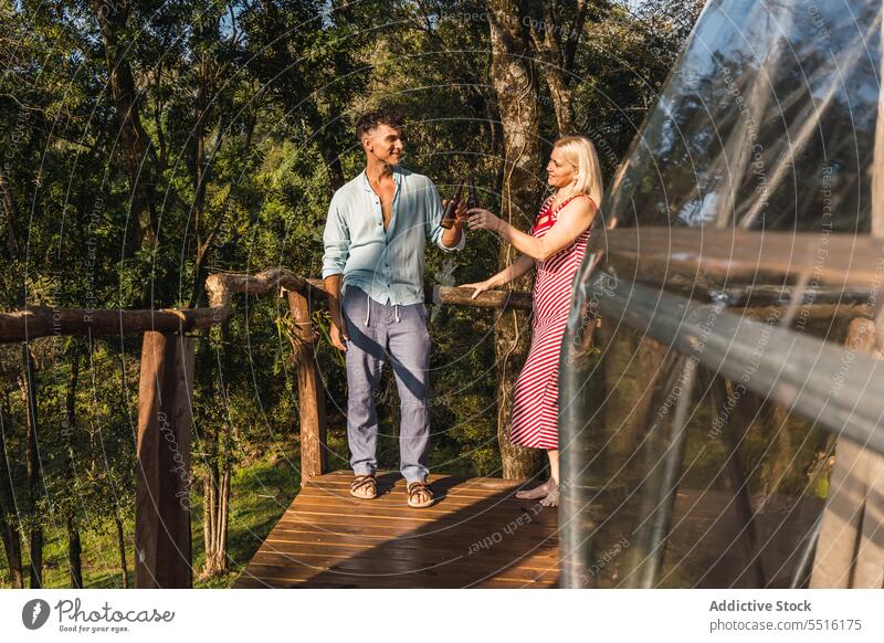 Pärchen mit Bierflaschen auf der Terrasse des Glamping Domes Paar glamourös Klirren Urlaub Freizeit Wochenende sich[Akk] entspannen feiern Zusammensein Sommer