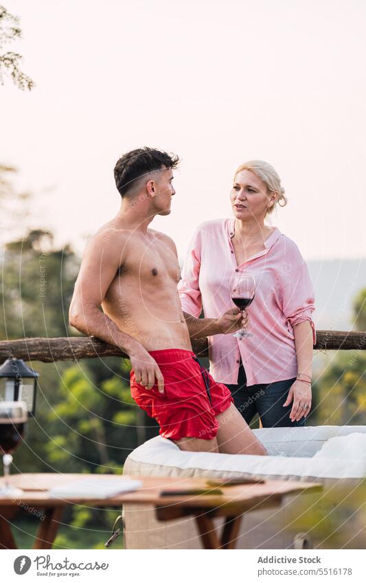 Mann und Frau stehen zusammen auf der Terrasse Paar reden Freund Zusammensein Reling trinken sprechen Gespräch männlich Freundschaft Getränk Glas Kommunizieren