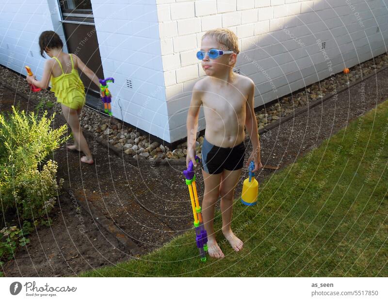 Junge mit Wasserspielzeug Mädchen Schwimmbrille spielen spritzen Spielen Freude Sommer nass Schwimmen & Baden Schwimmbad Ferien & Urlaub & Reisen