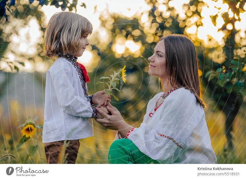 Porträt der schönen Familie - 4 Jahre alter Junge gibt Sonnenblume zu Mutter, Natur Mama Sohn Glück Umarmung Liebe Eltern Pflege Fröhlichkeit umarmend