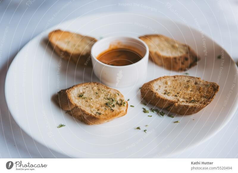 Knoblauchbrot auf einem weissen Teller mit einer kleinen Schüssel Sauce in der Mitte Essen Lebensmittel Kräuter & Gewürze frisch Zutaten Gemüse Farbfoto