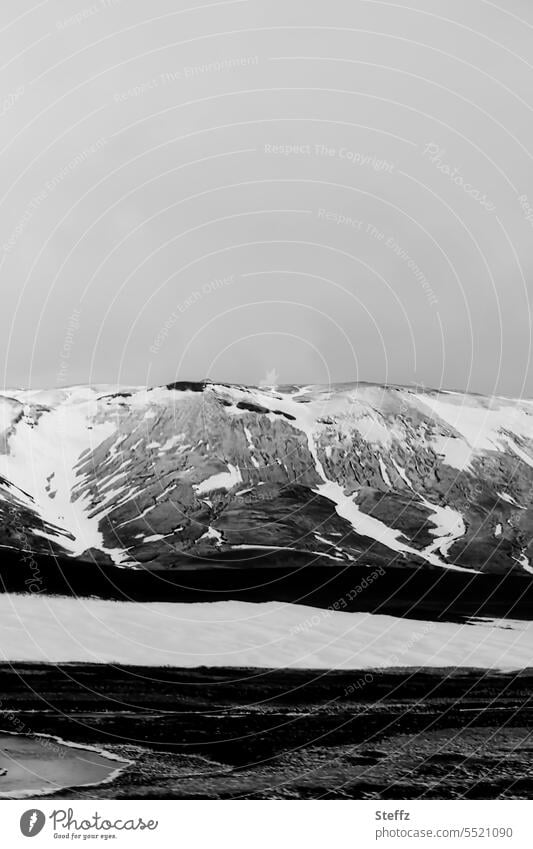 Schneeschmelze auf der Bergseite auf Island Nordostisland isländisch Schneeformen Iceland Schneereste abstrakt Islandreise Himmelgrau Formen Islandwetter