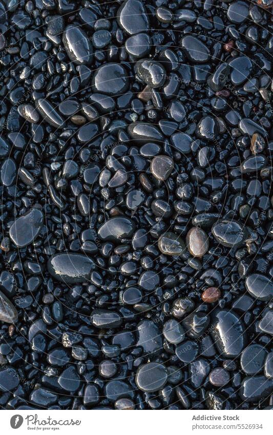 kleine Felsen am Reynisfjara Strand Kieselsteine sedimentär nass Ufer Abend Natur sanft Textur Hintergrund Geologie Stein Küste Formation Landschaft Felsbrocken