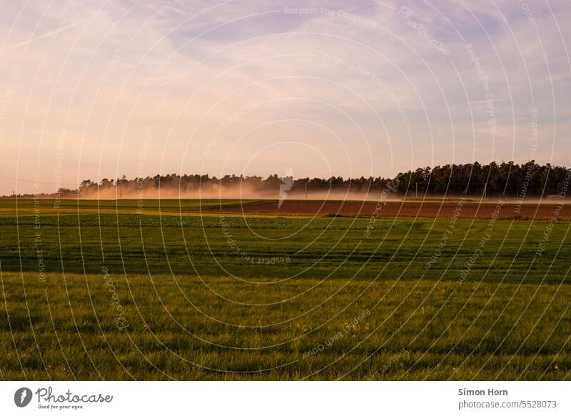 Nebel liegt über Landwirtschaftsflächen Nebelschwaden Abendlicht Felder Tagwerk Feierabend Agrarfläche Landschaft Feldarbeit Waldrand neblig Wiese Ernte