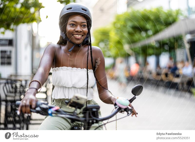 Porträt einer jungen Frau mit ihrem Fahrrad in der Stadt Erwachsener attraktiv schön schwarz Selbstvertrauen selbstbewusst cool Mädchen Frisur Freizeit