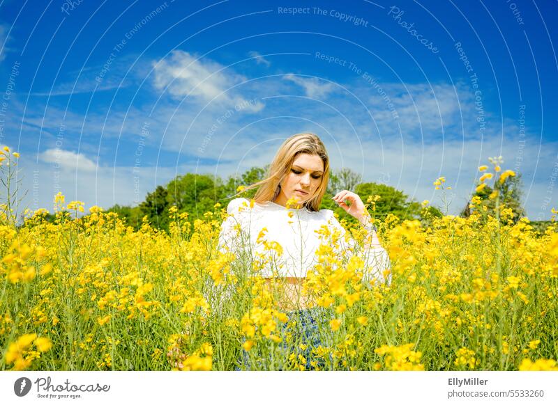 Junge blonde Frau im Rapsfeld jung Freiheit Portrait gelb Feld Natur Sommer Frühling Blühend Pflanze Blüte Umwelt Nutzpflanze Rapsblüte Landschaft Rapsanbau