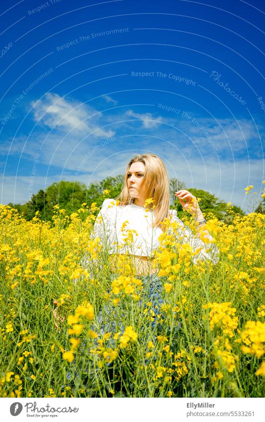 Junge blonde Frau im Rapsfeld jung Freiheit Portrait gelb Feld Natur Sommer Frühling Blühend Pflanze Blüte Umwelt Nutzpflanze Rapsblüte Landschaft Rapsanbau