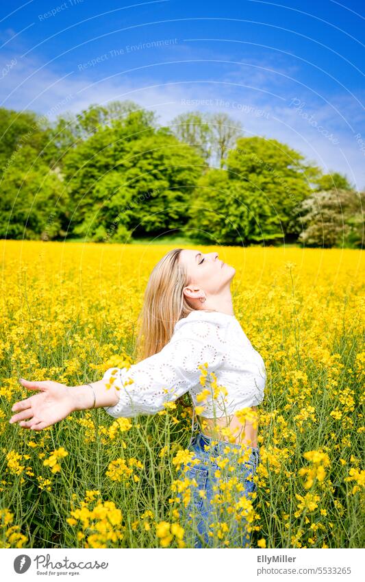 Junge blonde Frau im Rapsfeld jung Freiheit Portrait gelb Feld Natur Sommer Frühling Blühend Pflanze Blüte Umwelt Nutzpflanze Rapsblüte Landschaft Rapsanbau