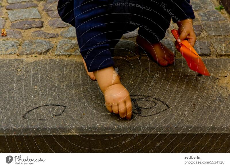 Jemand malt ein Bild kind spiel spielplatz kleinkind familie enkel malen kreide kreidemalerei künstler kunst zeichnung zeichnen pflastermalerei farbe mauer