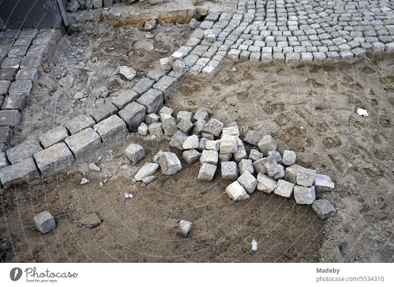 Straßenbau und Baustelle mit Verlegung von Pflasterstein als traditionelles Kopfsteinpflaster auf losem Sand in der Altstadt von Brügge in Westflandern in Belgien