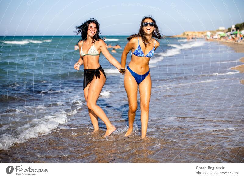 Zwei hübsche junge Frauen haben Spaß am Meer Erwachsener Strand schön Bikini sorgenfrei heiter genießen Genuss Freizeit Freunde Freundschaft Fröhlichkeit Glück