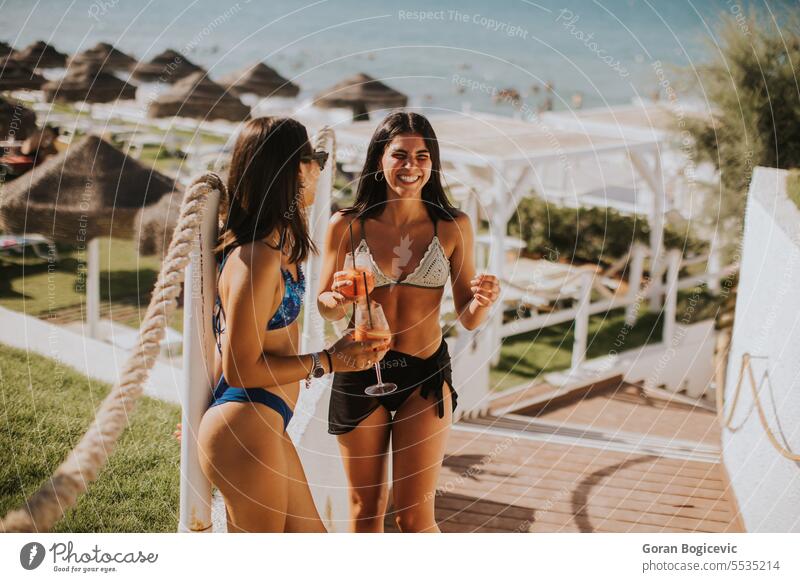 Lächelnde junge Frauen im Bikini genießen den Urlaub am Strand Erwachsener Bekleidung Tag trinken Emotion Mode Fröhlichkeit Feiertag Italien Freizeitaktivitäten