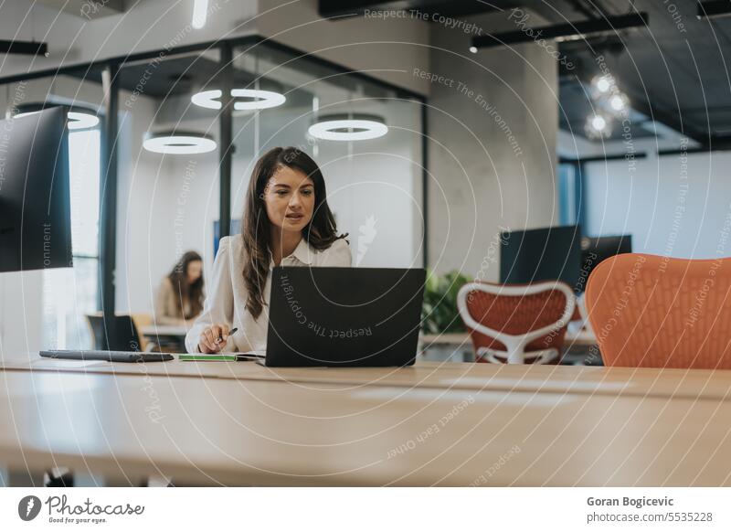 Junge Geschäftsfrau arbeitet am Laptop im modernen Büro Beruf Frau jung Glück sprechend eine Person professionell schön Anschluss Lächeln attraktiv Business