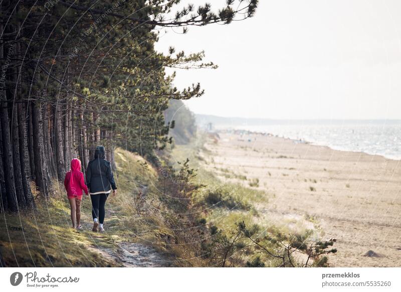 Familie spaziert im Wald am Strand entlang. Sommerurlaub Reise in der Nähe der Natur. Menschen verbringen aktiv ihre Freizeit. Genießen Sie lange Spaziergang während der Sommerzeit. Reise-Konzept