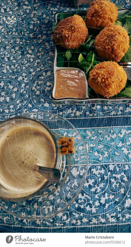 Vertikale Draufsicht auf Kartoffelkroketten und eine Tasse Masala Chai, ein bequemes Essen und ein gemütlicher Herbstnachmittagssnack vertikal Overhead