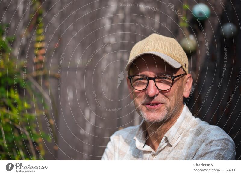 Weites Land | Gut gelaunter Mann mit Brille und Kappe Porträt Männerporträt Portrait Männerportrait gut gelaunt fröhlich Lächeln glücklich lächeln Mensch Freude