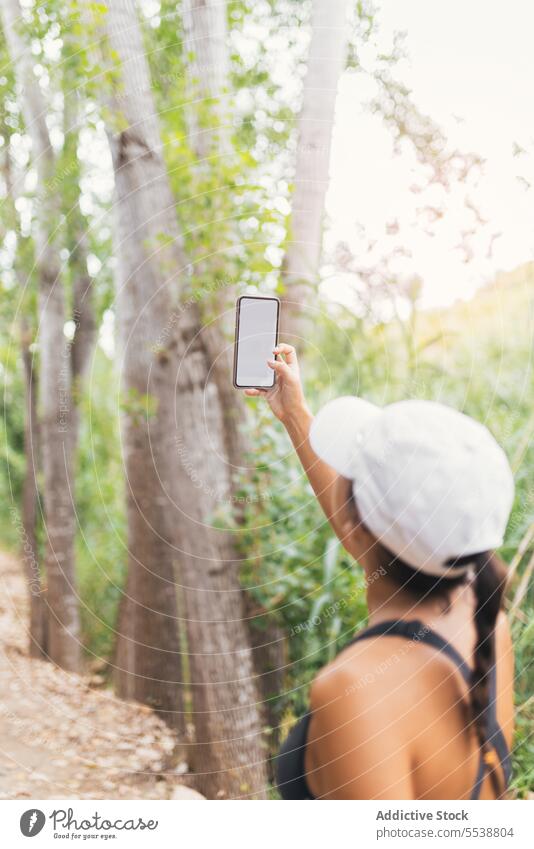 Weiblicher Wanderer macht Selfie im Wald Frau Lächeln Pause ruhen Wochenende reisen Smartphone Wälder Glück Hut Selbstportrait froh Reisender Baum Natur Mobile