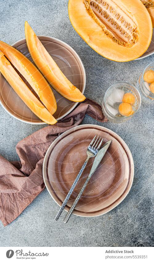 Frische Orangen-Moschus-Melone in Scheiben geschnitten und mit Melonenkugeln auf dem Tisch serviert orange frisch Frucht Glas gesunde Ernährung Eis lecker