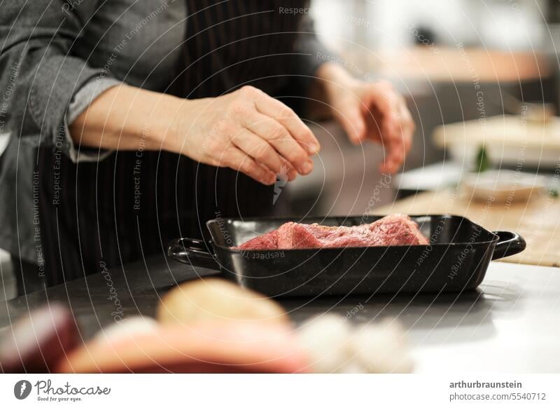 Rippenbraten vom Rind frisch von der Köchin in der Küche zubereitet mit Wildkräutern Ofenkartoffel und Karotten küche Küchenkräuter Küchenchef Pfanne ofenfrisch