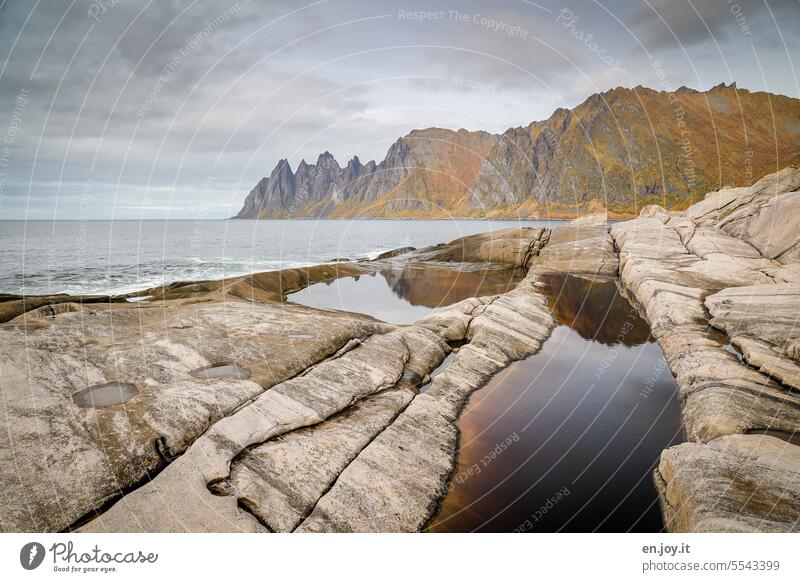 Die Teufelszähne auf Senja in Norwegen Insel Felsen Berge Meer Nordmeer Horizont Herbst Wasserpfützen bewölkt Reisefotografie Skandinavien