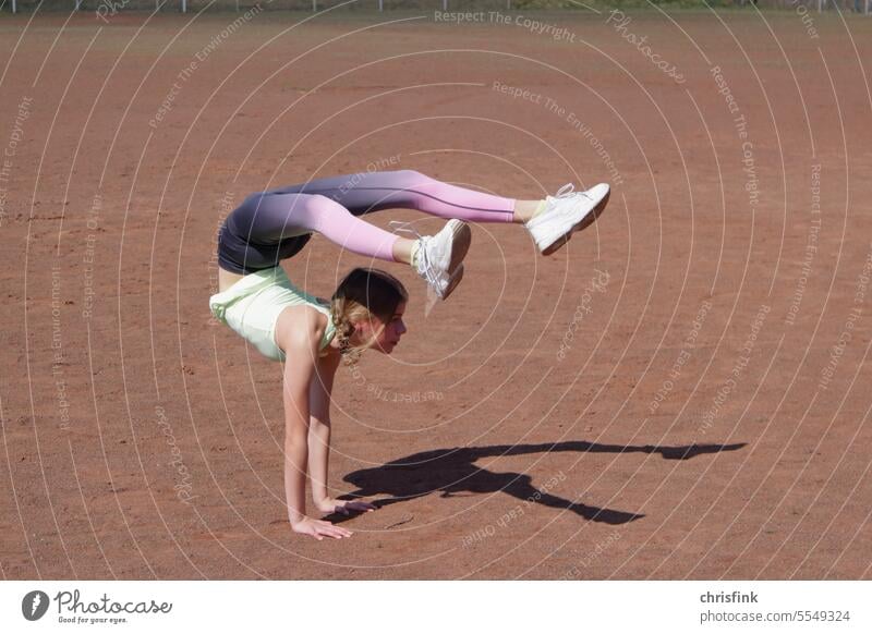 Gymnastin auf Sportplatz in Pose Turnerin Turnen Gymnastik Verbiegen contorsion beweglichkeit schatten sportplatz jugend schönheit Jugendliche Fitness