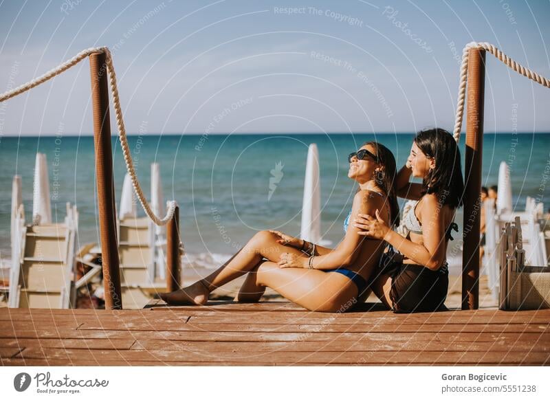 Lächelnde junge Frauen im Bikini genießen den Urlaub am Strand Erwachsener attraktiv Kaukasier Bekleidung Tag Emotion Mode Freunde Freundschaft Spaß Freundinnen