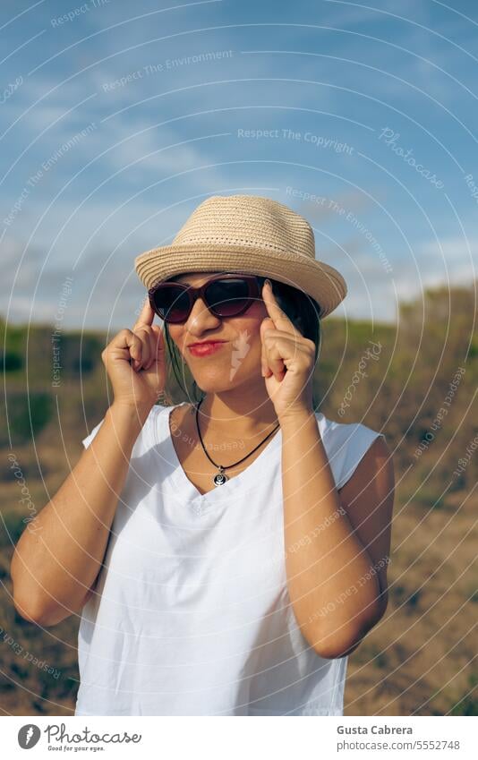 Eine Frau rückt ihre Brille zurecht und zieht eine Grimasse. Gesicht Porträt Gesichtsausdruck Blick Ausdruck Körperhaltung Gefühle Textfreiraum lustig lässig