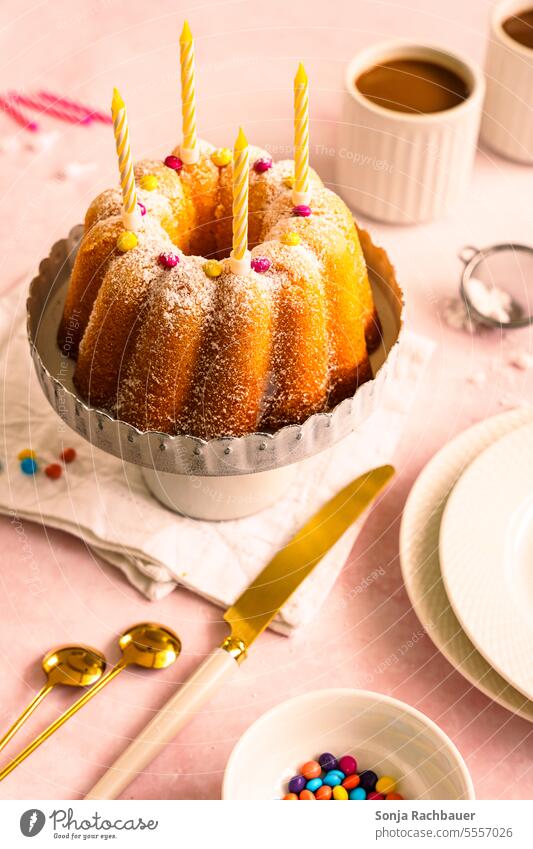 Ein Gugelgupf mit Kerzen auf einem Tisch Gugelhupf Kaffee Tasse Geburtstag Kuchen lecker Farbfoto Ernährung Menschenleer Innenaufnahme Kaffeetrinken