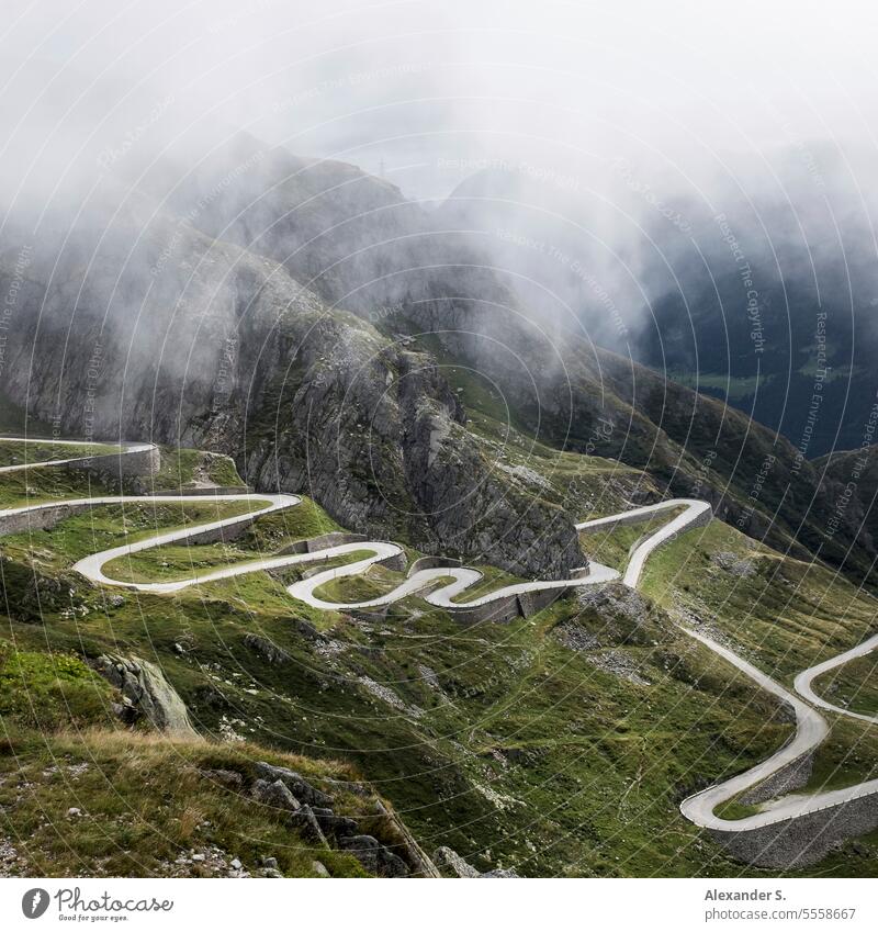 Serpentinen der alten Straße über den Gotthardpass in den Schweizer Alpen Passstraße Bergstraße Bergpass Gebirge Nebel Tessin Schweizer Alpenpass