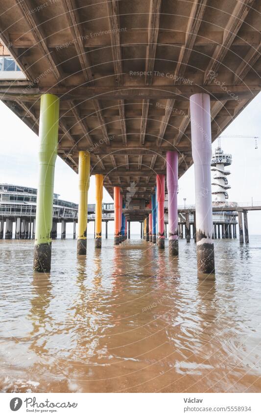 Bunte Sockel für eine riesige Seebrücke am Strand von Den Haag an der Westküste der Niederlande. Strand im amerikanischen Stil Ständer Ausflug Riesenrad