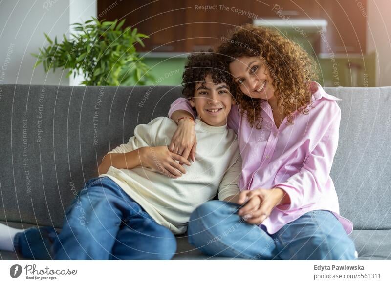 Glückliche Mutter und Sohn sitzen auf dem Sofa im Wohnzimmer zu Hause echte Menschen Erwachsener Appartement Bonden Junge Kind Familie Frau heimwärts