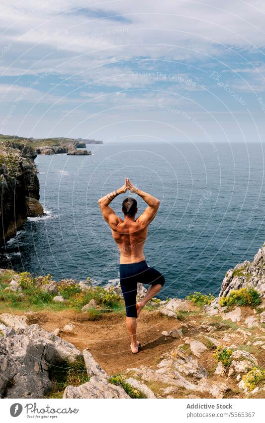 Meditativer Moment auf der Klippe Mann Yoga Pose Meer Hund Meditation Natur ruhig Achtsamkeit Küstenlinie Meereslandschaft Frieden Erholung Fokus Gleichgewicht