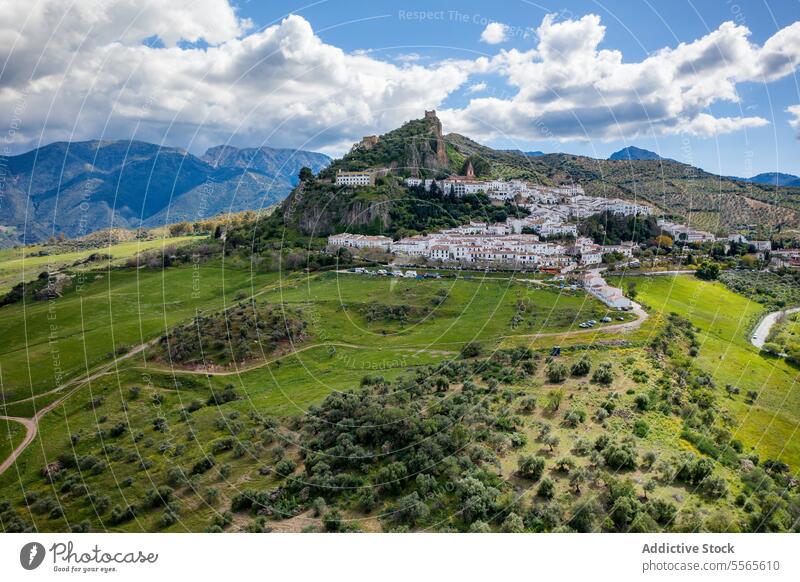 Berge mit grünem Tal und Dorf unter bewölktem Himmel Berge u. Gebirge Hügel Straße Landschaft Natur Kamm malerisch Zahara de la Sierra Spanien Pueblos Blancos