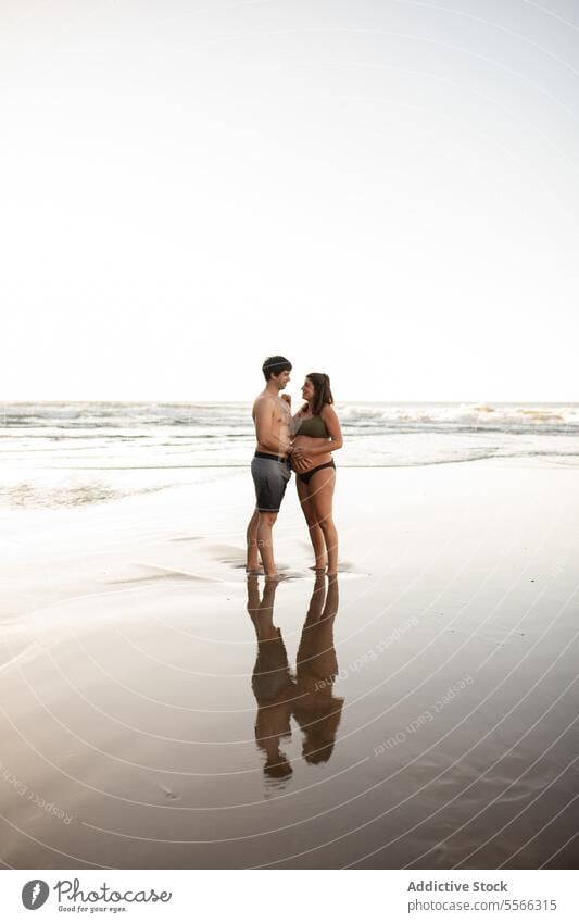 Lächelnder Mann berührt den Bauch einer schwangeren Frau am Meer Paar MEER Sonnenuntergang berühren Zusammensein Liebe Schwangerschaft Abend Angebot Sommer