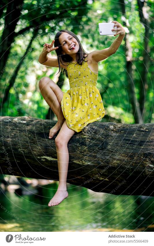 Preteen Mädchen sitzen auf Baumstamm während der Aufnahme selfie Wald Kofferraum Pause Erholung Natur Abenteuer ruhig genießen Sommer Harmonie Feiertag Ausflug