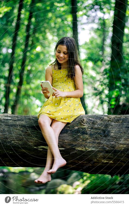 Preteen Mädchen sitzen auf Baumstamm während der Aufnahme selfie Wald Kofferraum Pause Erholung Natur Abenteuer ruhig genießen Sommer Harmonie Feiertag Ausflug