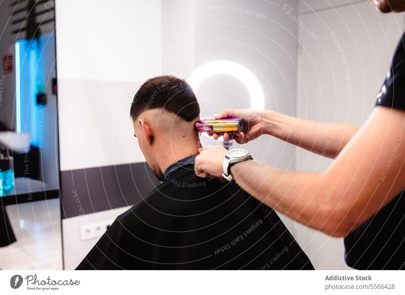 Friseur-Präzisionstrimm mit elektrischer Schermaschine. Klient männlich geschnitten entgittern Salon kurz Behaarung modern Technik Pflege stylen professionell