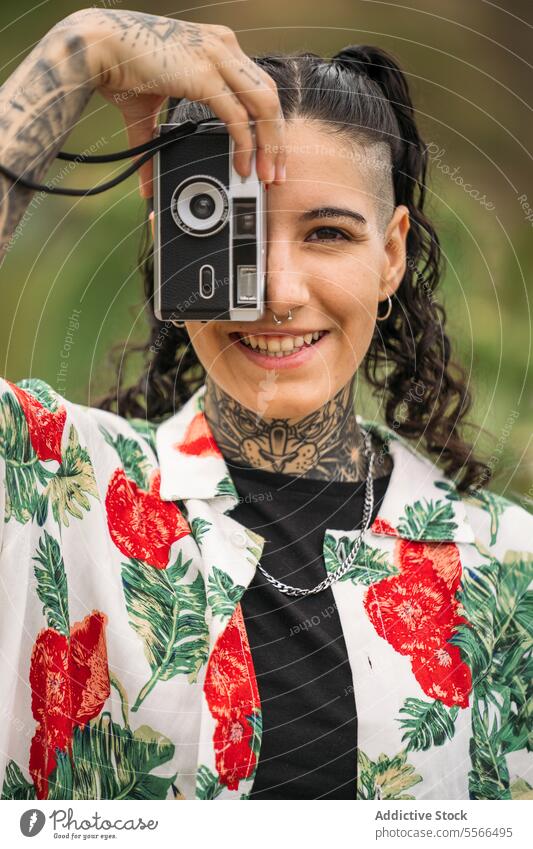 Lächelnde tätowierte Frau beim Fotografieren stylisch Natur genießend Tattoo Stehen attraktiv jung Mode hübsch Stil cool Schönheit trendy lässig Jugend Freizeit