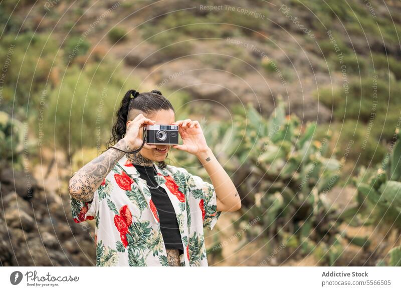 Lächelnde tätowierte Frau beim Fotografieren stylisch Natur genießend Tattoo Stehen attraktiv jung Mode hübsch Stil cool Schönheit trendy lässig Jugend Freizeit