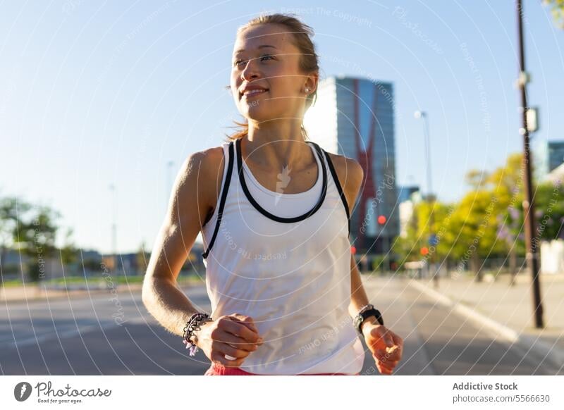 Eine Frau, die auf einem Bürgersteig in einer Stadt läuft laufen Großstadt urban Fitness Sport aktiv Metropolitan Lifestyle Dschungel Übung Straßenbelag joggen